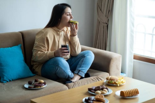 eating sugary food on sofa - food stock pictures, royalty-free photos & images