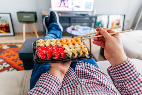 eating sushi delivery at home while laying on the couch, personal perspective view - junk food stock pictures, royalty-free photos & images
