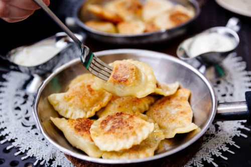 eating traditional polish dumplings pierogi with fork - food stockfoto's en -beelden