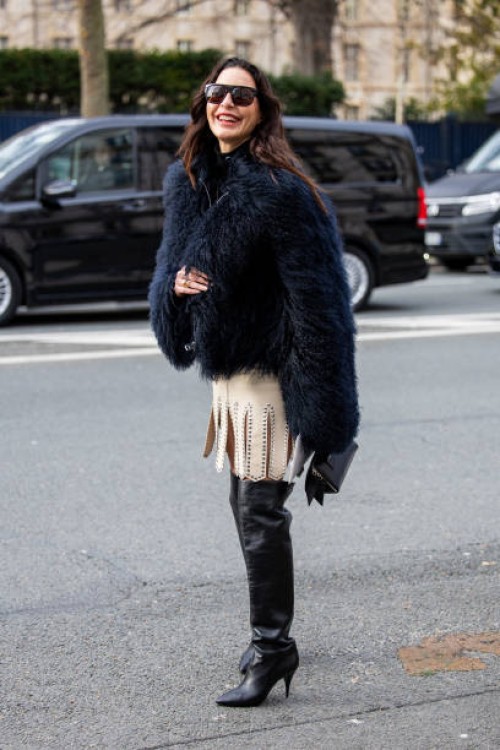 Ece Sukan wears navy faux fur jacket, beige skirt, over knees boots, sunglasses outside Dior during Haute Couture Spring-Summer 2025 as part of Paris...