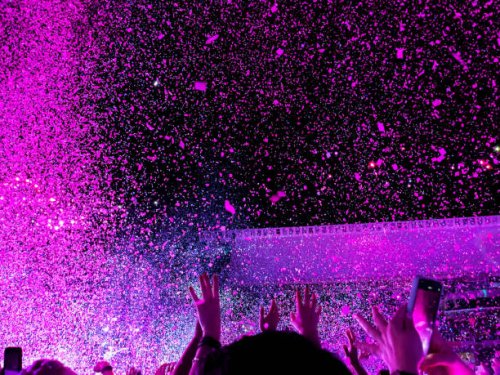 ecstatic people with energy dancing in a vibrant live music concert with pink confetti and crowd with hands up - concert stock pictures, royalty-free photos & images