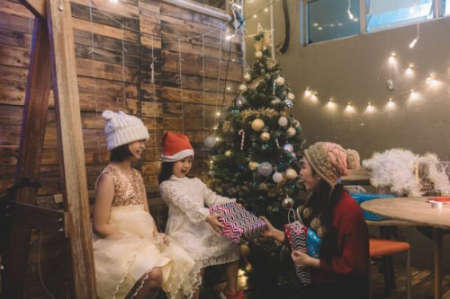 eine asiatische chinesische schwester, die ihren 2 geschwistern nach dem abendessen weihnachtsgeschenk schenkt - garden decoration stock-fotos und bilder