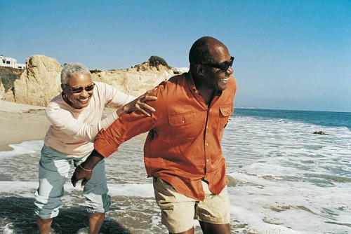 elderly couple messing about at waters edge - travel stock-fotos und bilder