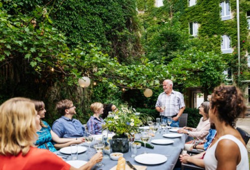 elderly man addressing his family during outdoor meal - garden decoration stock pictures, royalty-free photos & images