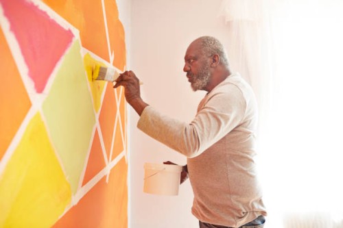 elderly man painting design on wall at home - home decoration stock pictures, royalty-free photos & images