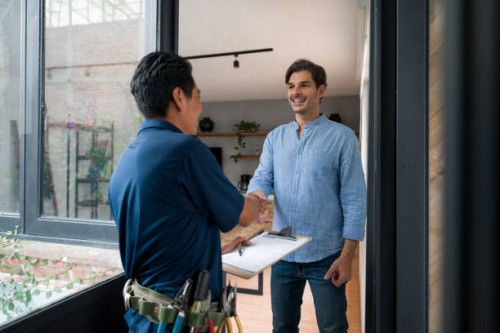electrician greeting a client with a handshake at the door of his house - home decoration stock pictures, royalty-free photos & images