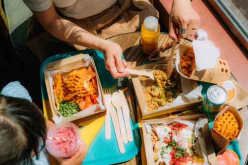 elevated view of young mother and her little girl sharing food at healthy fast-food restaurant - junk food stock pictures, royalty-free photos & images