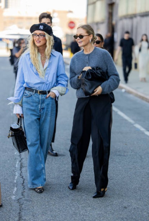 Emili Sindlev wears blue button shirt, beret, denim jeans, Hermes bag & Claire Rose Cliteur wears grey cardigan, black bag, pants outside Cos during...