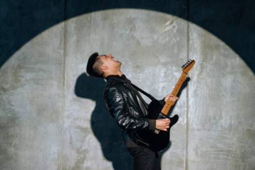 emotional man artist plays rock song on electric guitar and enjoys performing on stage. - concert stock pictures, royalty-free photos & images