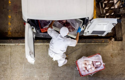 employee loading meat on a van for delivery at a butcher's shop - food stock pictures, royalty-free photos & images