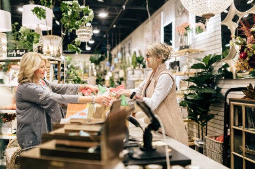 employee rings up customer for her purchase - home decoration stockfoto's en -beelden