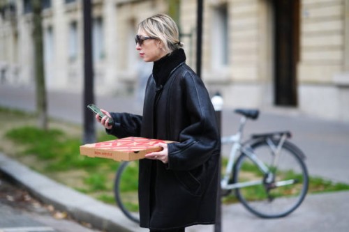 Emy Venturini wears sunglasses from Miu Miu, a gold earrings, a black turtleneck pullover from Cos, a black shiny leather with black sheep interior...