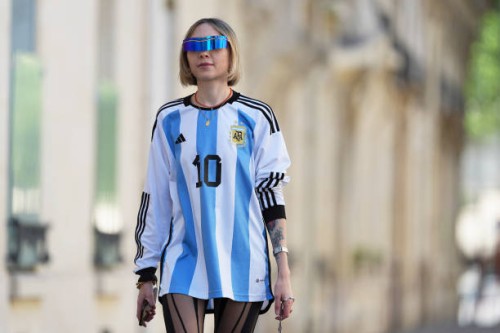 Emy Venturini wears sunglasses from Pierre Cardin, a blue and white striped Argentina soccer t-shirt from Adidas with printed "10" on the front and...