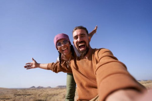 enthusiastic photo of nomadic couple taking a selfie showing the desert to post it on social media apps. - travel photos et images de collection