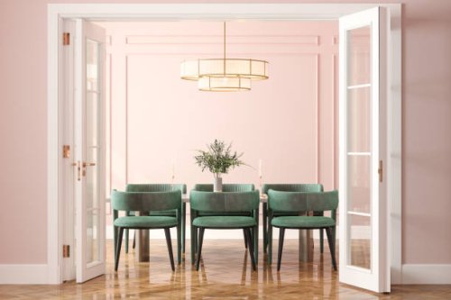 entrance of dining room with dining table, green velvet chairs and pink wall in background - home decoration stock pictures, royalty-free photos & images