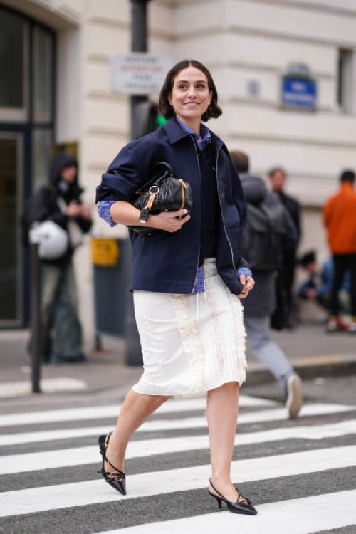 Erika Borldrin wears a blue jacket , a shirt, a polo shirt, a white knee-length skirt , pointed shoes, a leather bag, outside Miu Miu , during the...