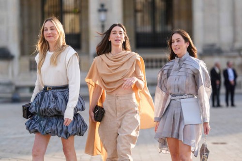 Este Haim wears white long sleeve Louis Vuitton shirt, black leather Louis Vuitton belt, dark blue puffy layered Louis Vuitton mini skirt. Danielle...