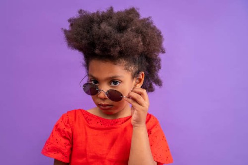 ethnic kid girl looking camera lowering sunglasses - fashion stock pictures, royalty-free photos & images