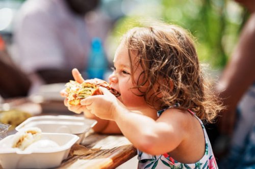 eurasian girl eating street food while vacationing in hawaii - junk food stock pictures, royalty-free photos & images