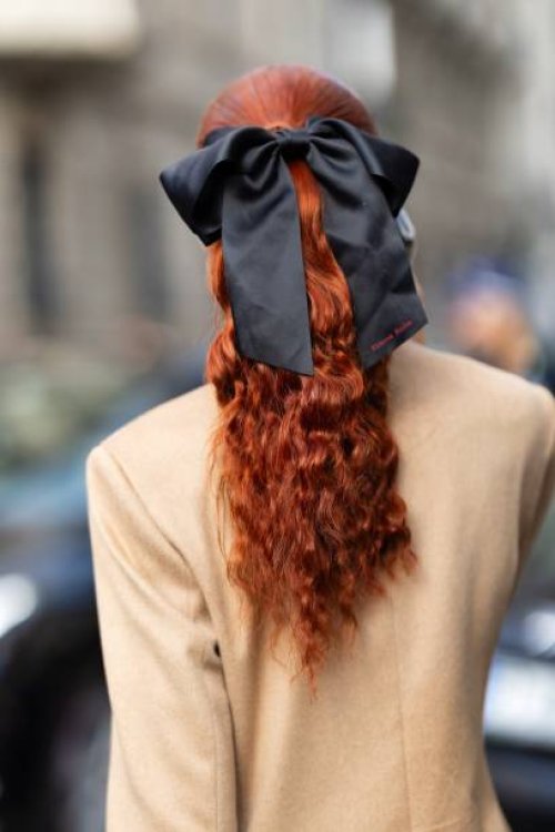 Evelyn Karantzoglou is seen red hair, a beige coat and a black bow wearing outside the Max Mara show during the Milan Fashion Week - Womenswear...