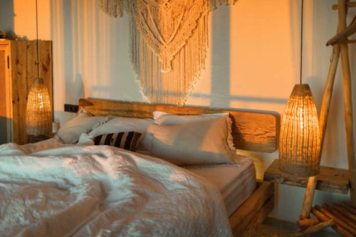 evening romantic mood in bedroom. stylish room with handmade design elements in boho style. beautiful light in cozy home. - home decoration stock pictures, royalty-free photos & images