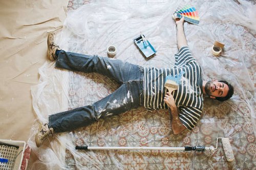 exhausted man resting after hard painting work - home decoration stock pictures, royalty-free photos & images