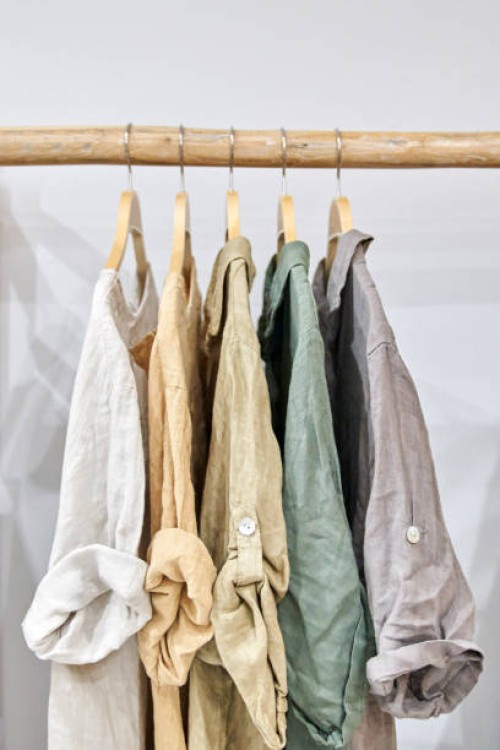 fair trade linen organic clothes of neutral tones on hanger - fashion stock pictures, royalty-free photos & images