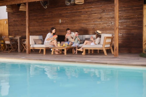 famille heureuse mangeant de la pastèque fraîche sur un patio au bord de la piscine. - garden decoration photos et images de collection
