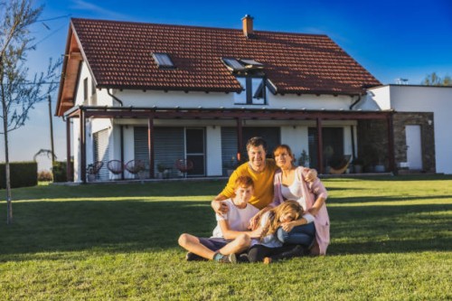famille, homme, femme, fils et fille assis sur la pelouse dans la cour arrière de leur maison au crépuscule, regardant quelque chose au loin - garden decoration photos et images de collection