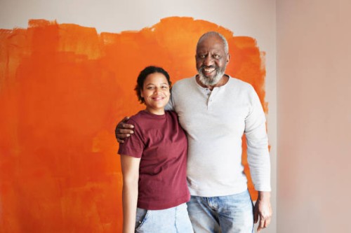 family against orange wall during home renovation - home decoration stock pictures, royalty-free photos & images