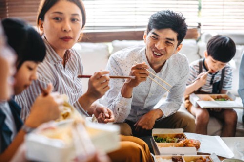 family eating takeout food in living room - junk food stock pictures, royalty-free photos & images