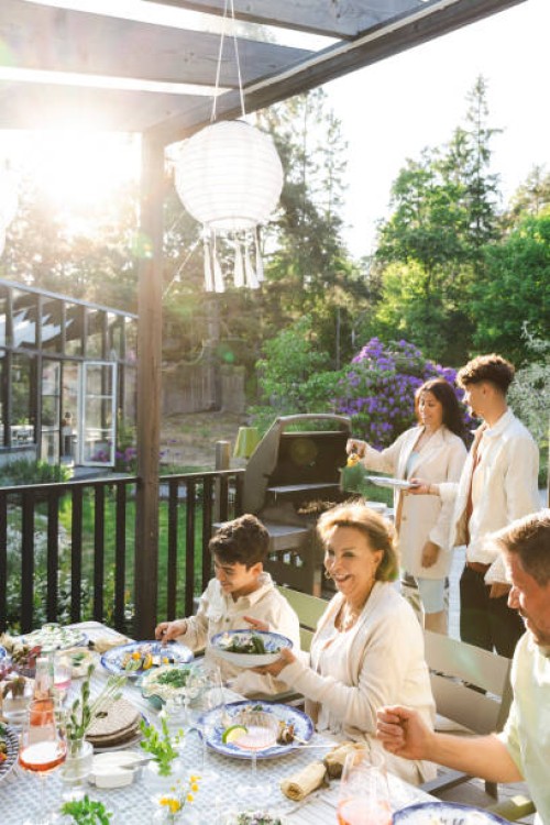 family enjoying summer dinner party at back yard - garden decoration photos et images de collection