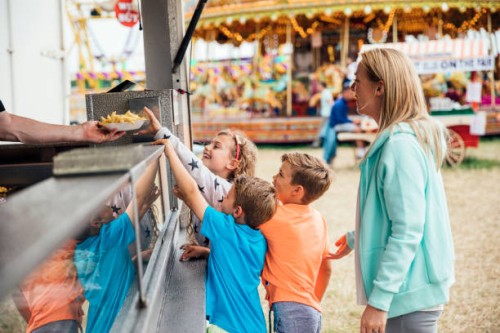 family getting food at the fairground - junk food stock pictures, royalty-free photos & images