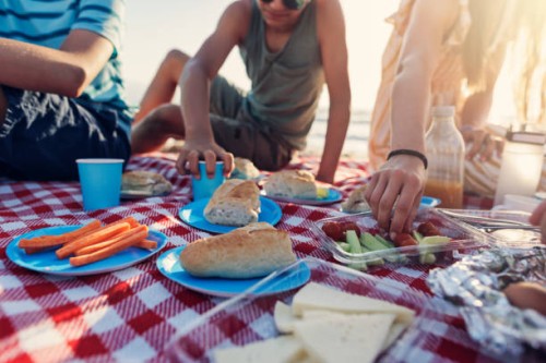 family having summer picnic breakfast on the beach - food stockfoto's en -beelden