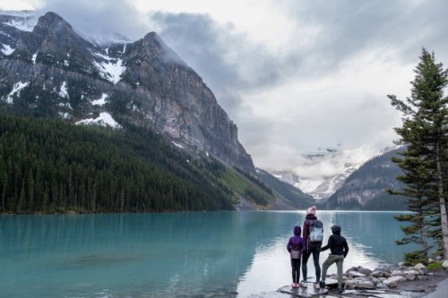 family hiking around a pristine glacial lake in banff national park - travel stock pictures, royalty-free photos & images