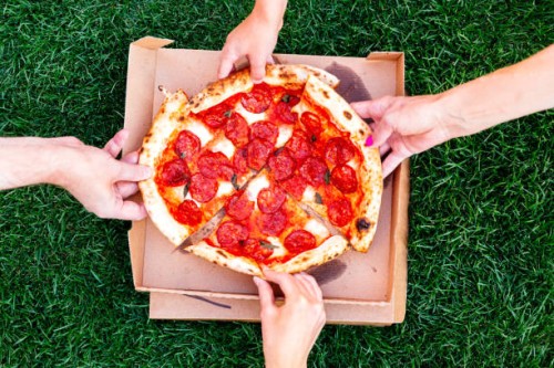 family of four sharing pizza, directly above view - junk food stock pictures, royalty-free photos & images