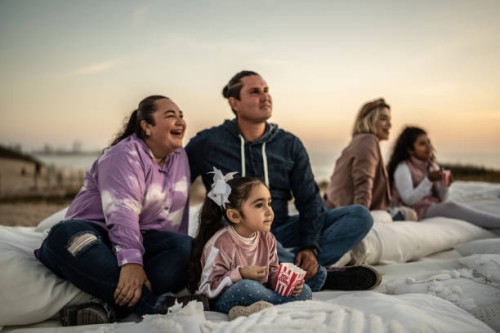 family watching a movie at outdoors cinema - concert stock pictures, royalty-free photos & images