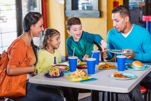 family with two children eating fast food - junk food stock pictures, royalty-free photos & images