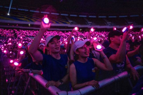Fans hold up LED lights as South Korean singer PSY performs during his "Summer Swag 2023" concert at Jamsil Olympic Stadium in Seoul on June 30, 2023.