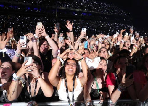 Fans watch Taylor Swift perform onstage during night two of "Taylor Swift | The Eras Tour" at La Defense on May 10, 2024 in Paris, France.