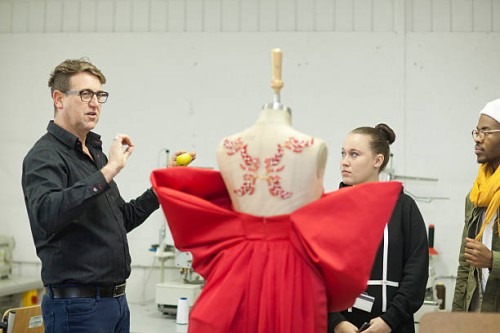 fashion design teacher assessing students work - fashion stock pictures, royalty-free photos & images