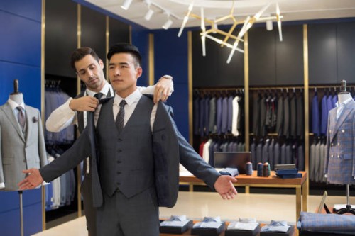 fashion designer examining suit on customer - fashion stock pictures, royalty-free photos & images
