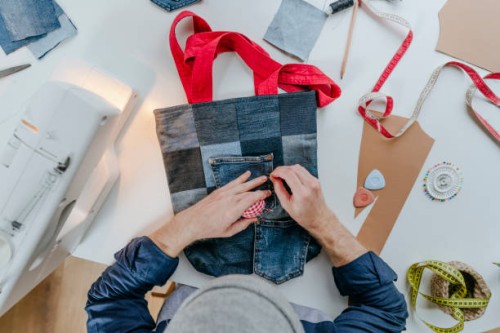 fashion designer stitching pocket on shopping bag - fashion stock pictures, royalty-free photos & images
