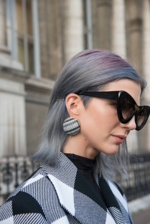 Fashion influencer Samantha Angelo of The Eye Travels wears a Marques Almeida coat, Sunday Somewhere sunglasses and Balenciaga earrings day 2 of...