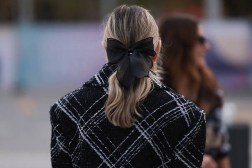 Fashion week guest is seen wearing a black and white checked jacket with a black ribbon in her hair during the Chanel Show Womenswear Spring/Summer...