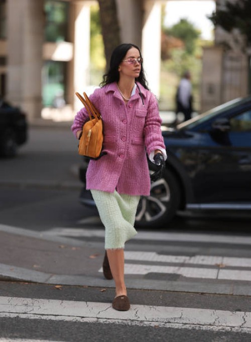 Fashion Week guest is seen wearing a pearl necklace, a complete outfit from Miu Miu, consisting of rimless oval sunglasses with pink mirrored lenses...