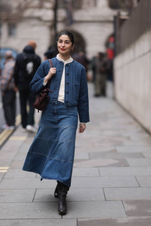 Fashion Week Guest seen wearing a blue denim long skirt, white shirt, blue jacket, brown leather handbag, black leather boots outside Charlie...