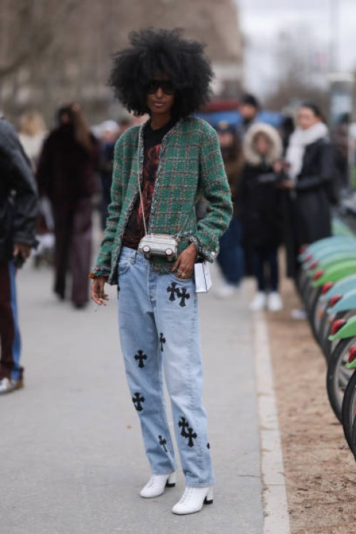Fashion Week Guest seen wearing a green checkered Chanel blazer, denim blue jeans pants with black details, white shoes, black shirt and black...