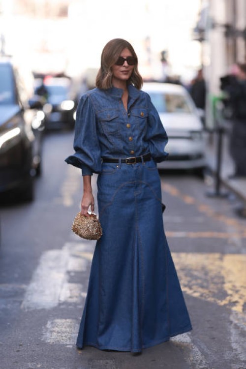 Fashion Week guest was seen wearing dark shades, a golden bag as well as a denim set from Zimmermann including a long denim jeans skirt with black...