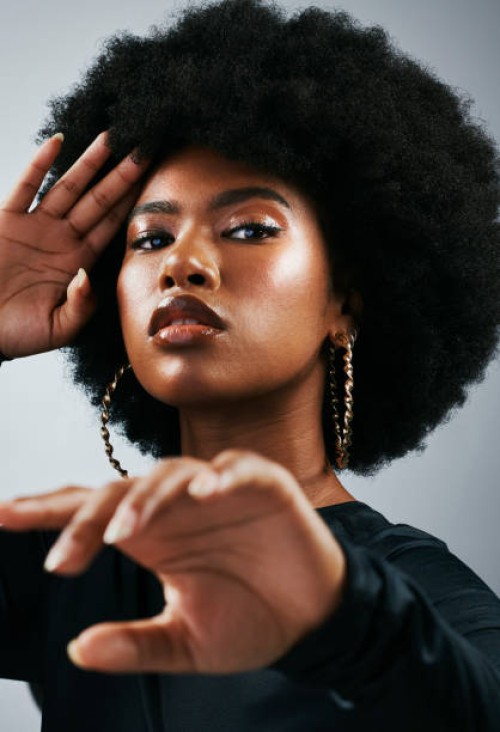 fashionable afro cover model with fierce, powerful attitude and funky, trendy hairstyle. powerful portrait of intense, retro and melanin woman against studio background in stylish fashion accessories - fashion stock pictures,